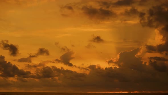 orange sky with clouds, moving clouds in the sky at sunset on the beach