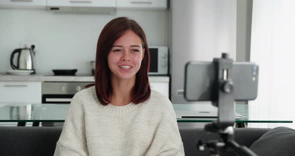 Focused Young Woman Streaming Live Webinar Using Mobile on Tripod Advertising Service Online alt