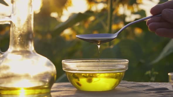 Sunflower Oil Flows From Tablespoon Into Glass Bowl. Production Organic Sunflower Oil, Bottle Of Oil alt