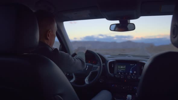 Young man driving a car on the road alt