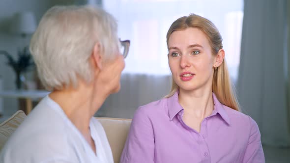 Young girl and elderly woman hugging and looking at the camera alt