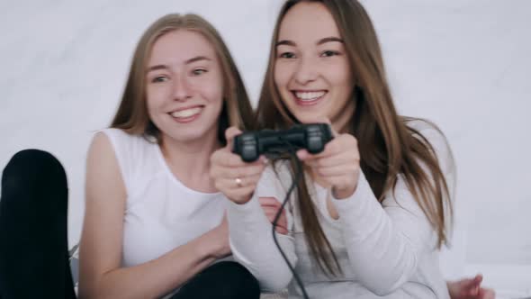Smiling Women Friends Playing Video Games at Home alt