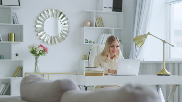 Young woman emotionally rejoices at good news at home alt