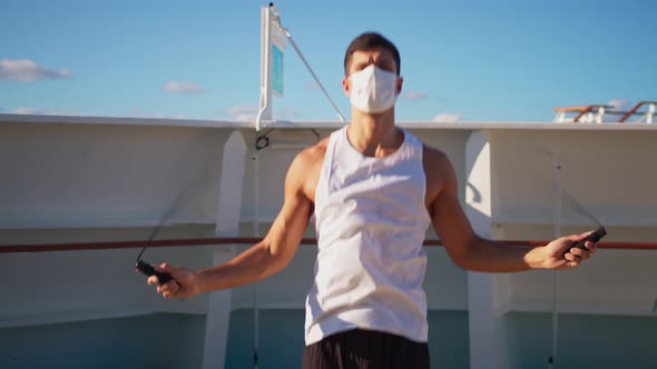 Handsome Young Man in Face Mask Jumps on Rope Outdoor