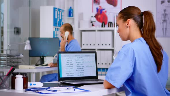 Back View of Resident Physician Checking Appointments on Laptop alt