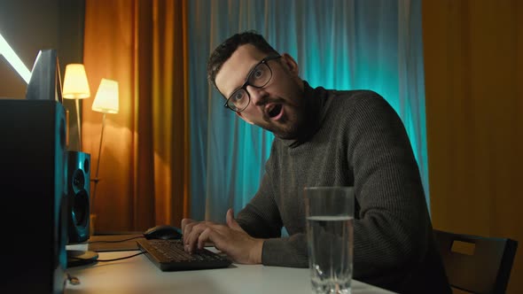 Funny Man Programmer Looking at Camera and Typing on Keyboard alt