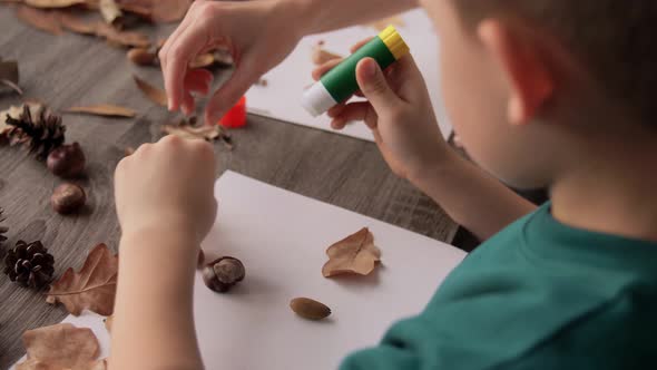 Mother and Son Making Pictures of Autumn Leaves alt