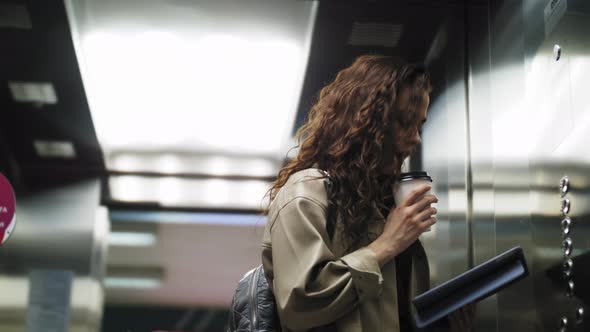 The Girl Uses a Tablet in the Elevator alt