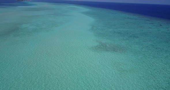 Wide angle overhead clean view of a paradise sunny white sand beach and aqua blue water background i alt