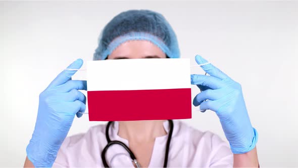 Close-up. Doctor in Glasses, Blue Medical Cap, Gloves Holds in Hands Medical Mask with Poland Flag alt