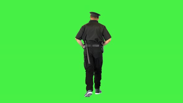 Young Policeman Walks Looking Around Adjusting His Cap on a Green Screen Chroma Key