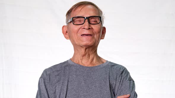 The old Asian man smiled happily showing his missing teeth and holding dentures in his hand. alt