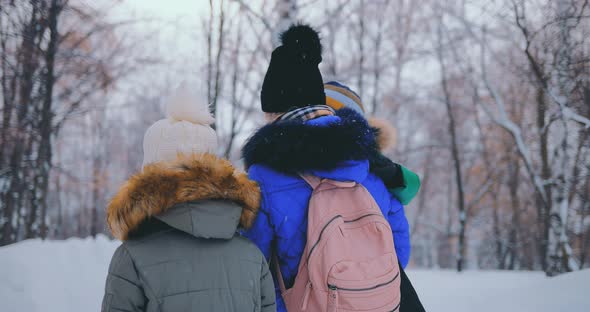 Young Mother Walks with Children in the Winter