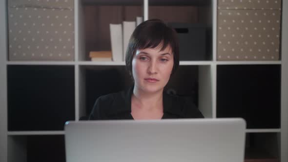 Young freelancer woman working on laptop from home. Worker developing working at home. alt