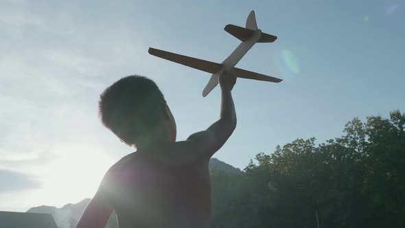 Boy Running With A Cardboard Airplane With Sun alt