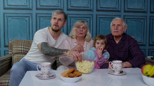 Multigenerational Family Getting Scared Watching Horror Television Movies Eating Popcorn at Home alt