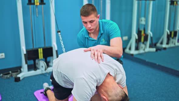 Young Man Doing Exercises Under Physiotherapist Supervision alt