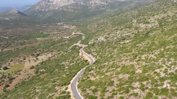 Aerial view car travels едет по дороге in beautiful mountainous terrain.