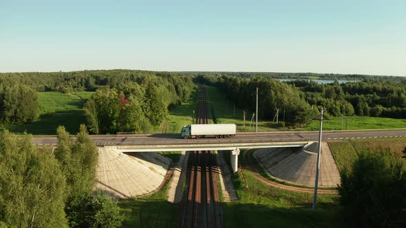 Flying Over Car Road Junction With Bridge And Railway Under It At Sunny Day alt