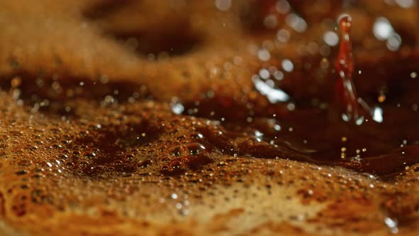 Super Slow Motion Macro Shot of Splashing Fresh Coffee and Water Droplets at 1000 Fps alt