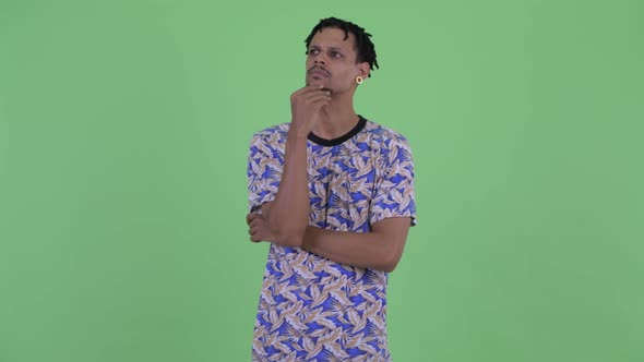 Happy Young Handsome African Man Thinking and Looking Up alt