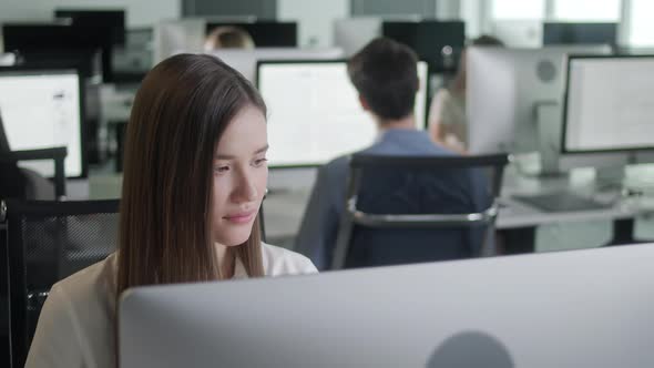 Attractive Young Woman Working on Decktop Computer While Working in Big Open Space Office alt