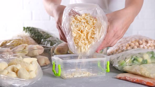 The woman is pouring frozen cheese into a container.