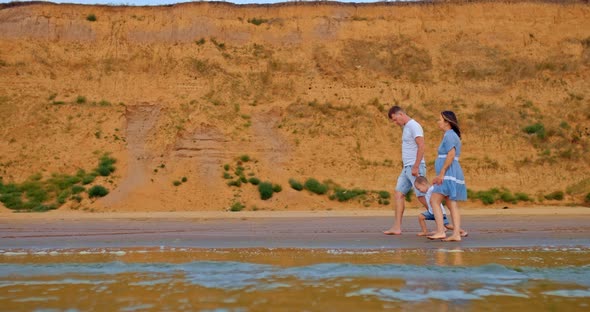Happy Family Walks Along the Shore Bare Feet Walking on the Sand