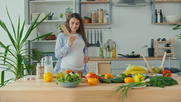 Happy Pregnant Woman Dancing in the Kitchen in the Morning alt