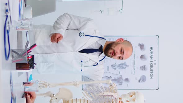 Vertical Video Medical Doctor Man Pointing on Cervical Spine of Human Skeleton alt