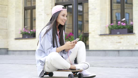 Woman sitting on the skateboard