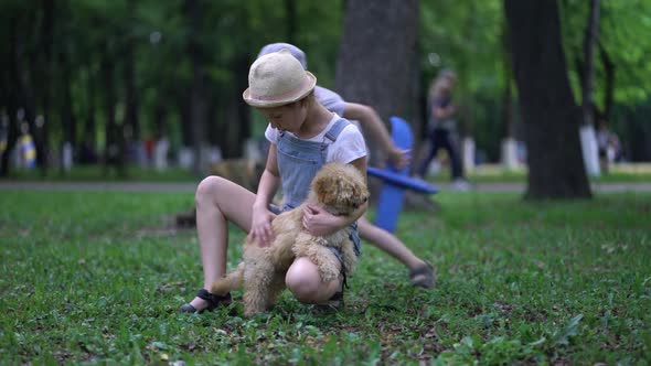 Little Boy with Plane and Girl Play with Cute Poodle Dog Outdoors in Park