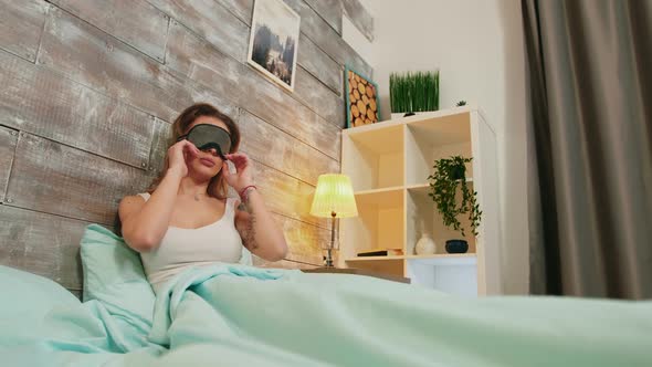 Young Woman with Pajamas Sleeping with Mask Over Her Eyes alt