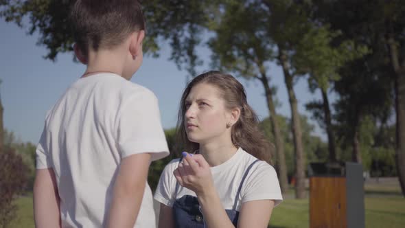 Strict Older Sister Scolding Her Younger Brother in the Summer Park ...