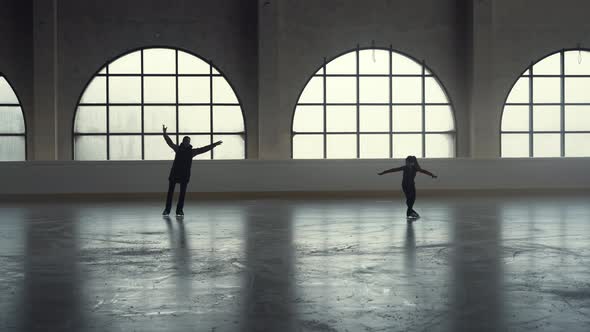 Woman Coach and Student Little Girl Skating on Dark Ice Arena alt
