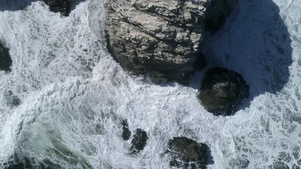 Drone Descending Through Towering Cliffs With Foamy Waves At Piedra de la Piramide In Linares, Chile alt