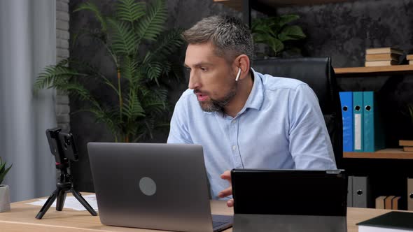 Shocked Man Stock Trader Broker Looks at Laptop Tablet and Smartphone Screen alt