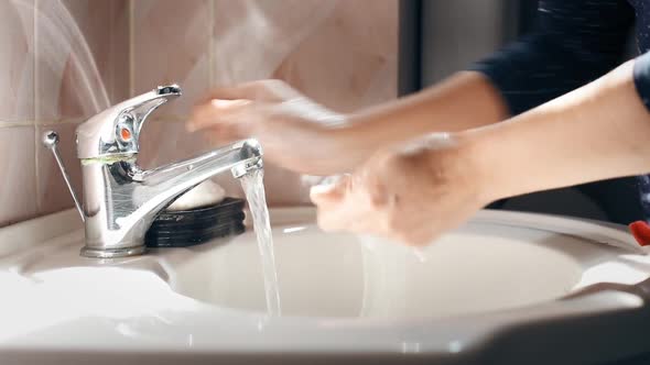 Woman washing her hands.