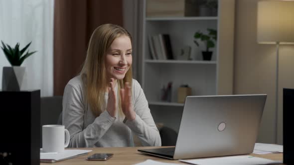 Overjoyed young woman surprised victory looks at the laptop sitting in the office alt