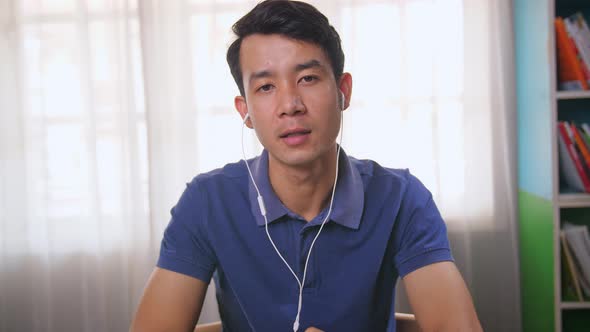 Asian Man Talking On Video Conference alt