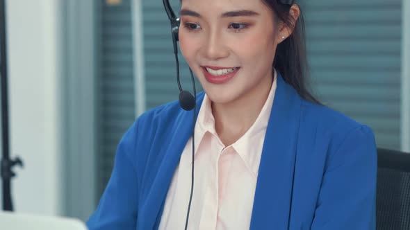 Businesswoman Wearing Headset Working Actively in Office alt
