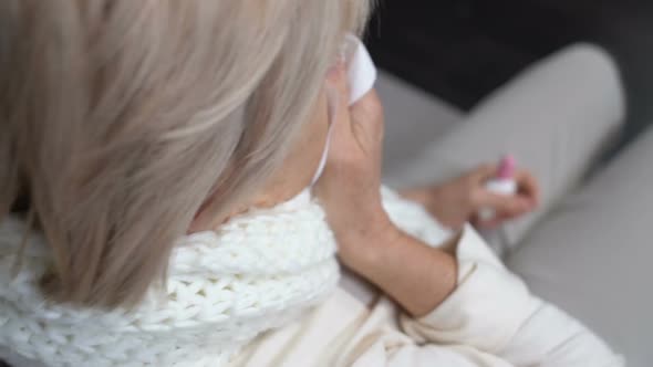 Sick Old Woman Sneezing in Tissue Using Nasal Spray, Seasonal Allergy Problem