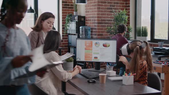 Single Mother with Child at Office Girl Having Fun with VR Headset While Mom is Working with alt