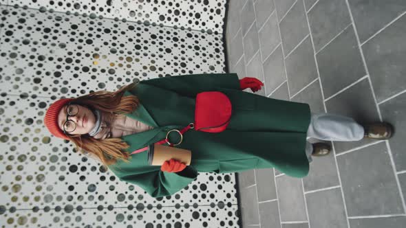 Woman Holding Coffee Cup and Walking Outdoors alt