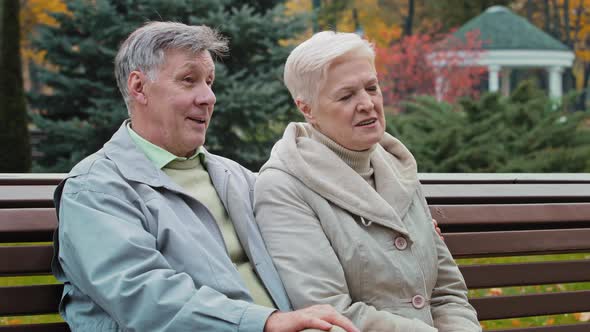 Caucasian Elderly Family Rest Time Together in Autumn Park Sit on Bench Married Couple Partners alt