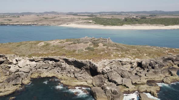 Drone pan of rugged Pessegueiro Island with ancient fort; Porto Covo