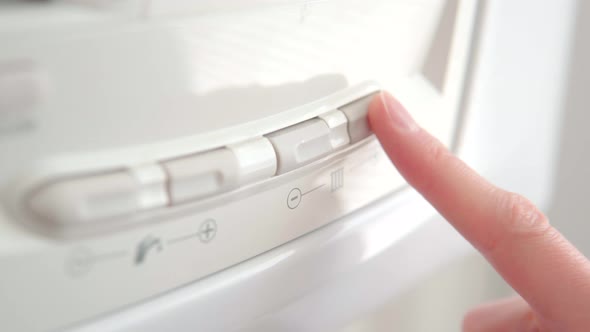 Female Finger Adjust the Temperature on the Home Gas Boiler for Hot Water and Heating