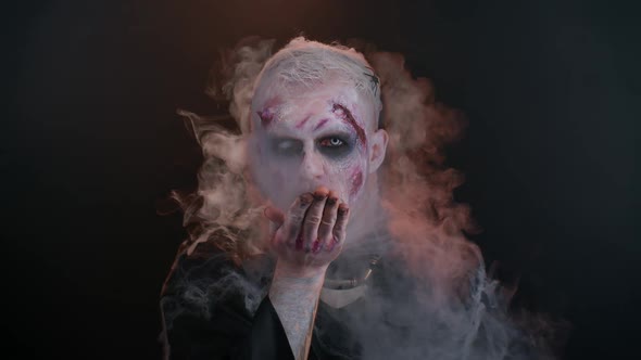 Sinister Man Halloween Zombie with Bloody Face Blows Smoke From Nose and Mouth Making Air Fly Kiss alt