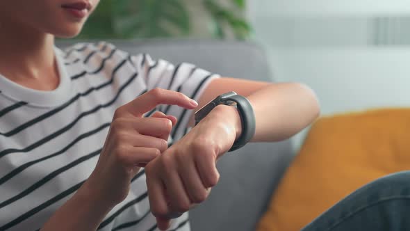 Woman hand touching screen on smartwatch to unlock