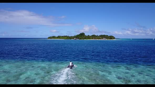 Aerial flying over panorama of tranquil lagoon beach holiday by blue sea with clean sandy background alt